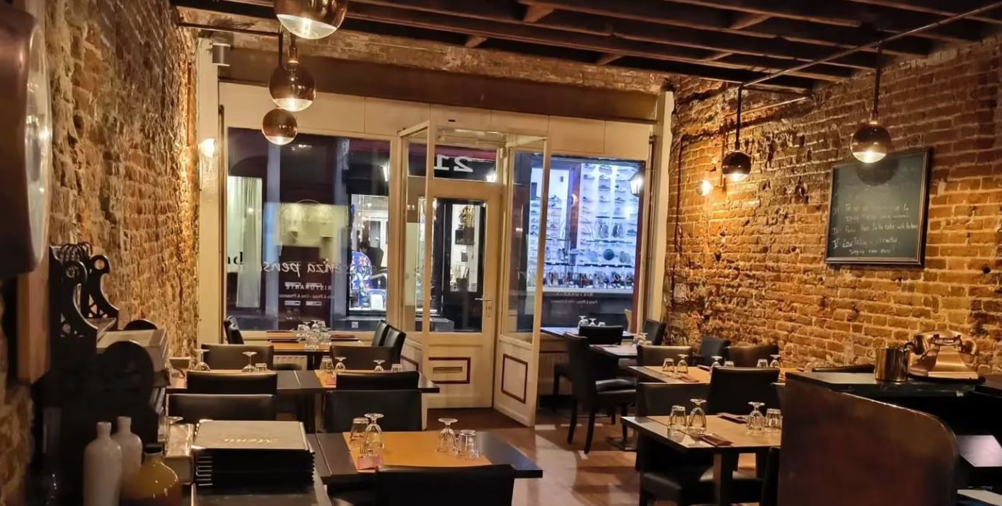 Sala interna del ristorante con tavoli apparecchiati e pareti in mattoni a vista
